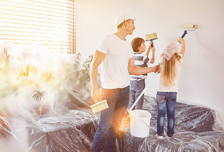 Vater mit Kindern beim Streichen