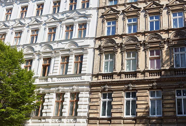 Zwei denkmalgeschützte Immobilien nebeneinander, eine ist energetisch saniert, die andere nicht